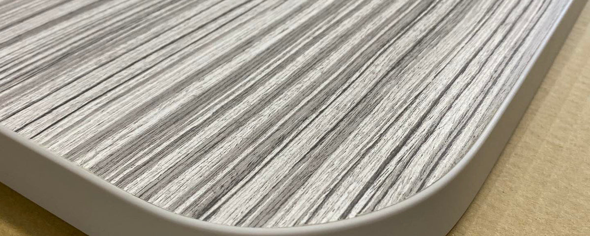 Corner of a laminated motorhome table top showing the radius and edging